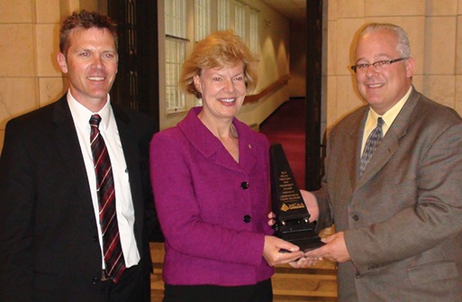 Jeff Buczkiewicz, MCAA President (r) presents Tammy Baldwin (D-WI) with the Freedom and Prosperity Award. Shown left is Joe Buechel,  Natural Stone Veneers International.